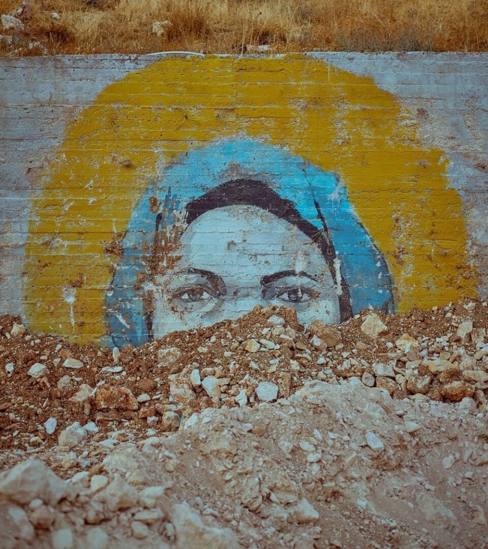 obraz przedstawiający mural z Matką Boską w aureoli przysypany ziemią